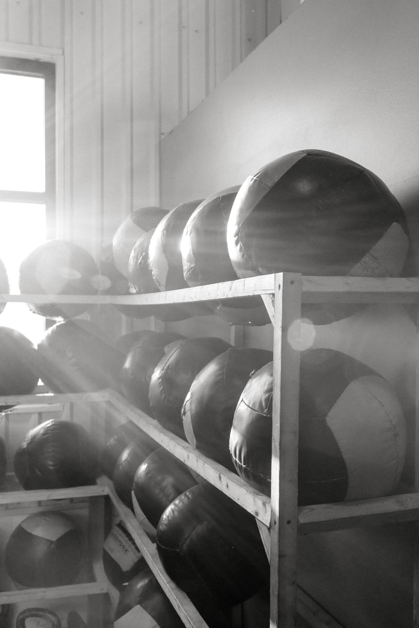 Medicine balls stacked on wooden shelves inside CrossFit Antietam